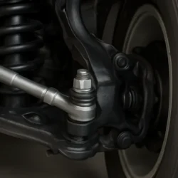 Front suspension and steering area of a Toyota Camry with a highlighted tie rod end being installed.